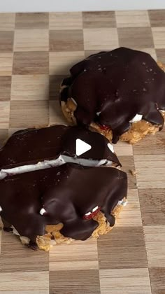 two chocolate covered cookies sitting on top of a checkered counter