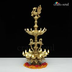 an ornate brass candle holder with five lit candles in the shape of swans on it