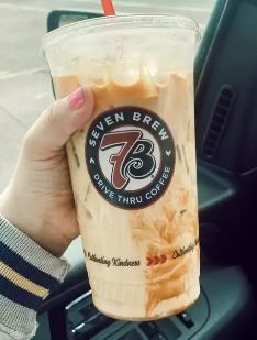 a person holding up a drink in their hand with the number seven on it's side