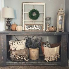 a shelf filled with decorative items next to a lamp and pictures on top of it