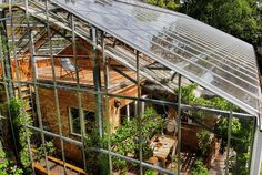 an aerial view of a greenhouse with lots of plants growing in the house's roof