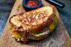 a grilled cheese sandwich sitting on top of a wooden cutting board