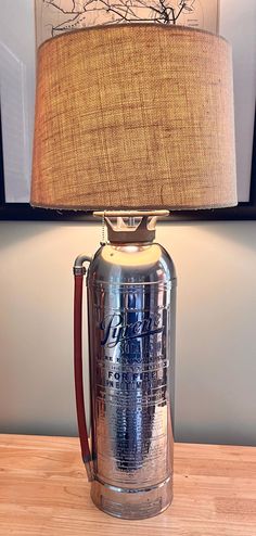 a lamp that is sitting on top of a wooden table next to a framed picture