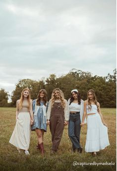 four girls standing together in a field