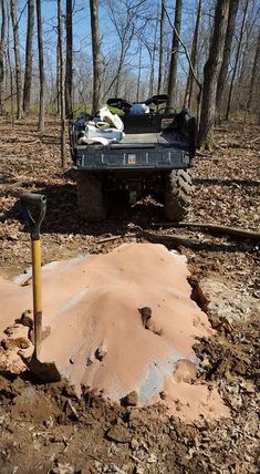 a truck parked in the middle of a forest with dirt on it's ground