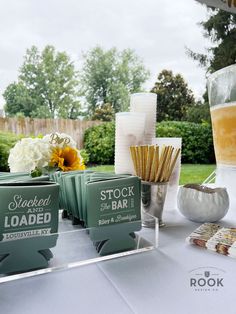 there are many items on the table for sale at this outdoor event, including drinks and snacks