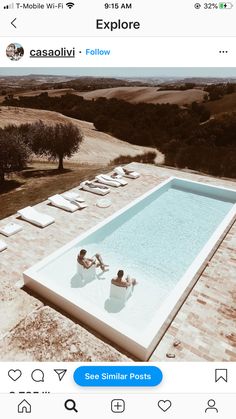 two people lounging on lounge chairs next to an outdoor swimming pool in the countryside