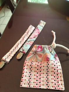 two pieces of fabric with polka dots and flowers on them sitting on a table next to a pair of scissors