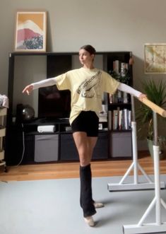 a young woman is practicing ballet moves in her living room