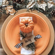 an orange plate topped with a napkin and pumpkin