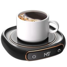 a cup of coffee sitting on top of an electronic device that is connected to a clock