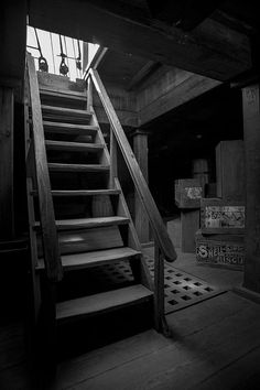 black and white photograph of stairs leading up to the top floor in an abandoned building