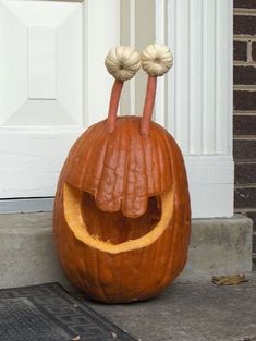 a pumpkin carved to look like a face with two hands sticking out from it's mouth