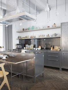 an industrial kitchen with stainless steel appliances and wood floors