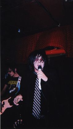 a man in a suit and tie singing into a microphone