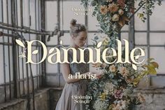 a woman standing in front of a flower covered wall with the words danielle on it