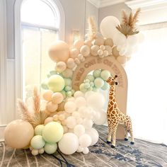 a giraffe standing next to a bunch of balloons