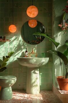 a bathroom with green tiles and potted plants in the corner, along with a white pedestal sink