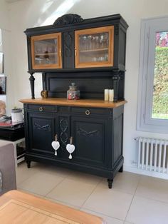 a black china cabinet with gold trim and glass doors