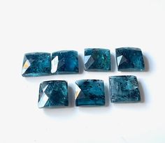 five blue diamonds sitting next to each other on a white surface