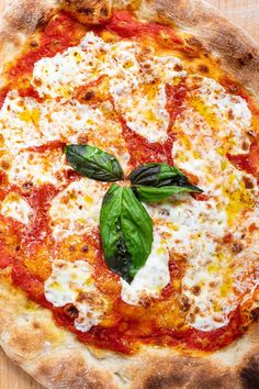 a pizza topped with cheese and basil leaves