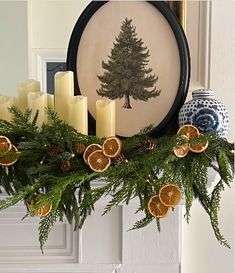 a mantel with candles and oranges on it