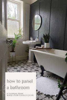 a white bath tub sitting next to a sink in a bathroom under a window with potted plants