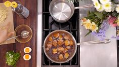 a pan filled with food sitting on top of a stove next to other cooking utensils