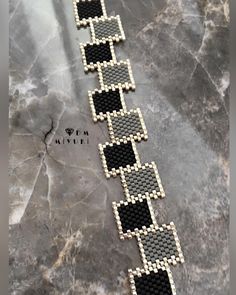 a black and white beaded bracelet on a marble surface