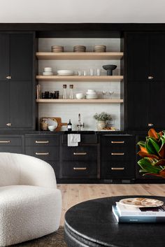 a living room filled with furniture and lots of shelves above it's counter top