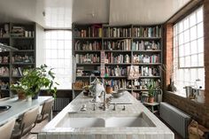 a kitchen with a sink and bookshelves in it