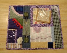 a close up of a quilted place mat on a wooden floor with many different items