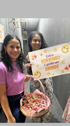 two girls holding up a sign and basket