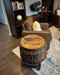 a living room filled with furniture and a wooden barrel