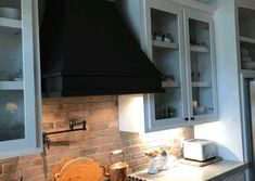 a stove top oven sitting inside of a kitchen next to white cabinets and counter tops