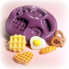 an egg, waffles, and pretzels on a pink background