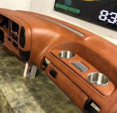 the interior of an old car with leather and chrome trims, including two center console buttons