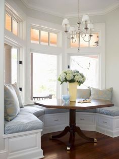 a room with a table, couches and chandelier