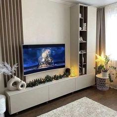 a flat screen tv sitting on top of a white entertainment center in a living room