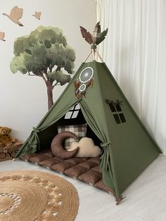 a green teepee tent sitting on top of a floor next to a stuffed animal