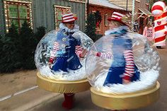 two people in snow globes walking down the street