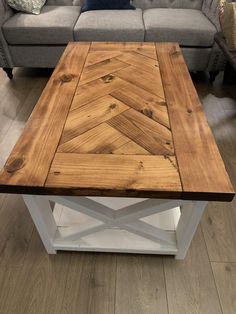 a wooden coffee table sitting on top of a hard wood floor next to a couch