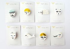 six brooches with different designs on them, all in white and yellow colors