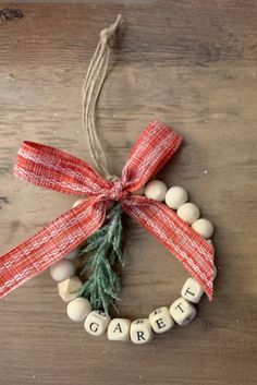 an ornament made out of wood beads with a red ribbon tied around it