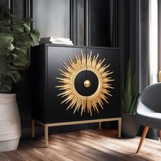 a black cabinet with a gold sun decoration on the front and side, next to a chair