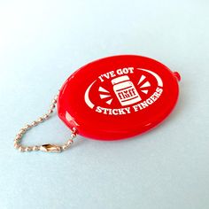 a red frisbee shaped keychain with the words i've got sticky fingers on it