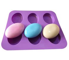 an egg tray with three different colored eggs in it