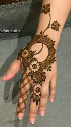 a woman's hand with henna tattoos on it