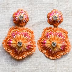 Floral Beaded Raffia Earrings, Handmade, Unique and Elegant Creation for Women, Gift Idea, Orange Earrings, Pink Earrings Casa Mayra Two toned Celia earrings make the perfect finishing touch to any evening outfit. This lightweight pair is cut into the shape of jawline-grazing Floral drops. These earrings are intricately embellished with tiny iridescent Orange japanese glass beads woven intricately with orange, fuchsia and white raffia with a sparkle of crystal stones. Backed with lightweight merino wool felt these earrings are a perfect show stopper.   Showcase yours with a sleek updo. Handmade Luxury Austrian Crystal Stones Iridescent orange Japanese glass beads Light Weight Gold Plated Pierced Posts  Raffia Length: total 6cm Width: Widest 4.5 cm Please note: Due to the handmade nature of Orange Beaded Flower Earrings, Orange Drop Earrings For Festive Occasion, Festive Orange Drop Earrings, Bohemian Earrings With Bead Caps For Party, Traditional Orange Earrings For Party, Orange Flower Shaped Earrings For Party, Elegant Drop Earrings With Bead Caps For Party, Party Bead Caps Drop Earrings, Party Drop Earrings With Bead Caps