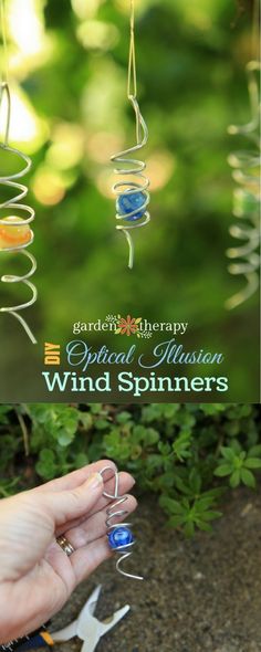 the wind spinner is being held up by someone's hand with their fingers